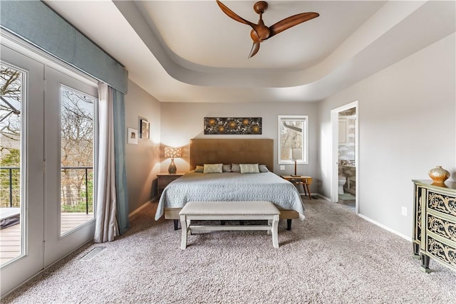 carpeted bedroom with visible vents, baseboards, a tray ceiling, ceiling fan, and ensuite bathroom