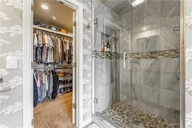 bathroom featuring a shower stall and a spacious closet