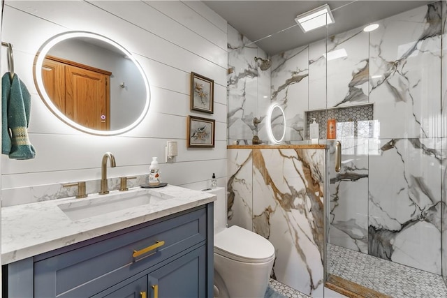 full bathroom with vanity, toilet, and a marble finish shower