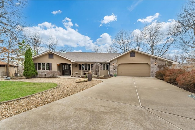 view of front of home with roof with shingles, a porch, an attached garage, concrete driveway, and stone siding