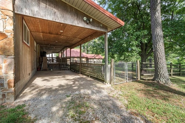 view of patio featuring a gate, an attached carport, fence, and driveway