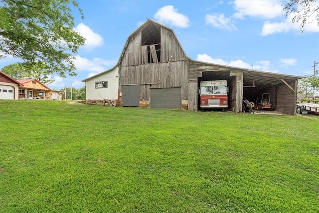 view of barn with a lawn and driveway