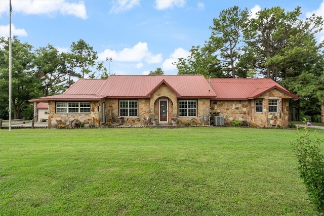 ranch-style home with stone siding, a front lawn, central AC unit, and metal roof