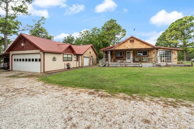 view of front of home featuring a garage, a front lawn, driveway, covered porch, and metal roof