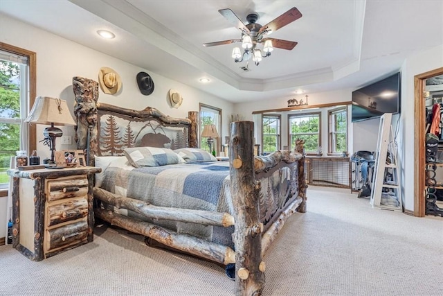 bedroom with carpet flooring, recessed lighting, ornamental molding, and a tray ceiling