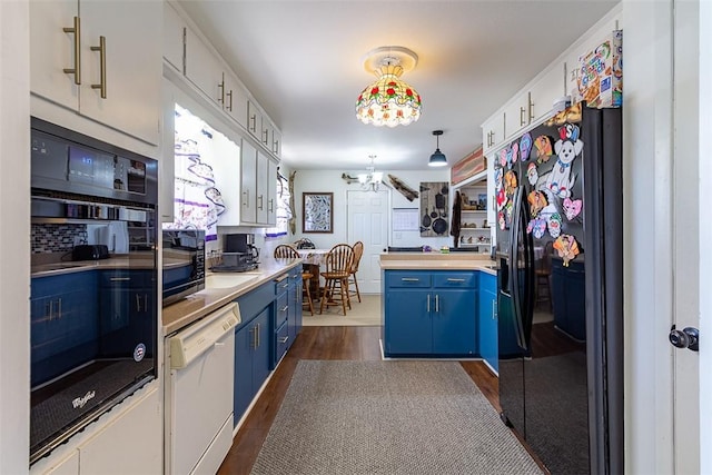 kitchen with dark wood-style floors, black fridge, dishwasher, blue cabinets, and a chandelier