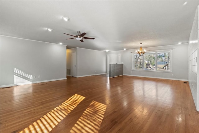 unfurnished living room featuring visible vents, ceiling fan with notable chandelier, baseboards, and wood finished floors