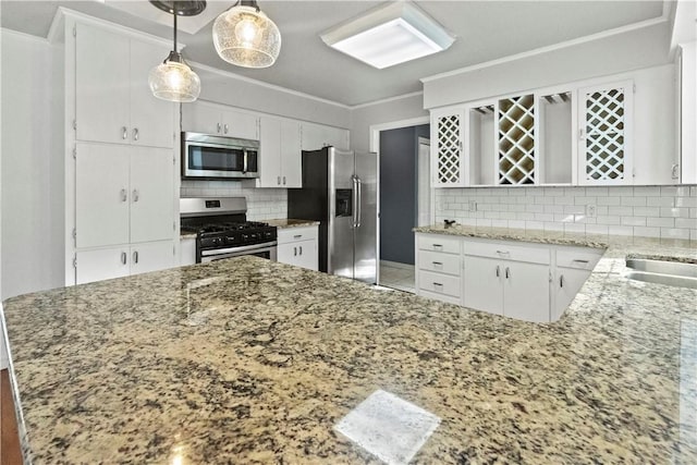 kitchen featuring stainless steel appliances, tasteful backsplash, ornamental molding, and white cabinetry