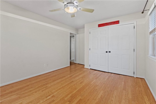 unfurnished bedroom with a closet, baseboards, light wood-style floors, and a ceiling fan