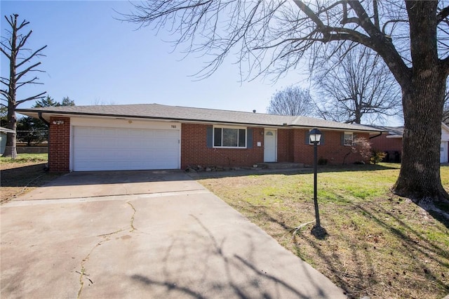 ranch-style home with a garage, driveway, brick siding, and a front yard