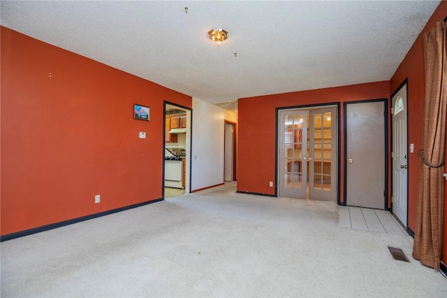 carpeted empty room featuring visible vents, baseboards, and a textured ceiling