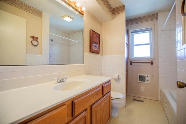 full bathroom featuring tile patterned floors, visible vents, toilet, tile walls, and vanity