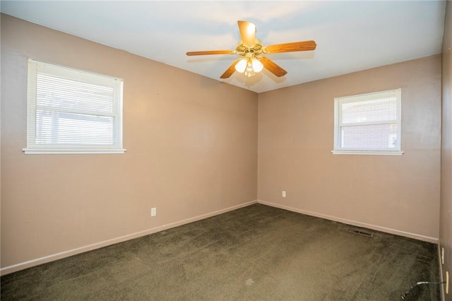 carpeted spare room featuring baseboards, visible vents, and ceiling fan