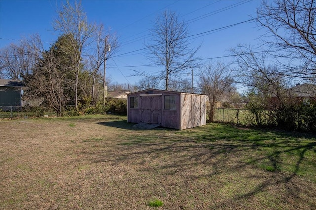 view of yard with an outbuilding, a storage unit, and fence