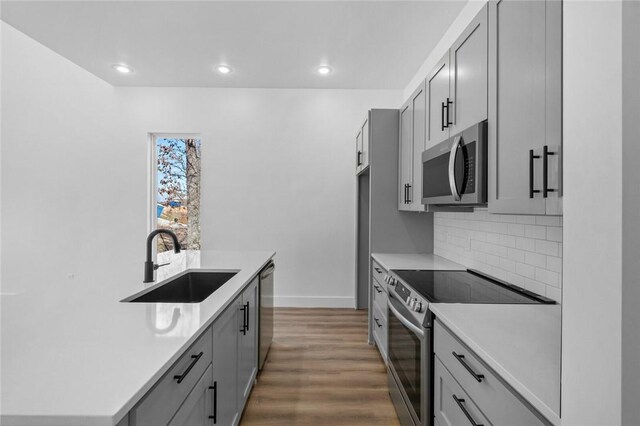 10 Reading Ln, Bella Vista, AR 72714 - kitchen featuring a sink, backsplash, appliances with stainless steel finishes, and gray cabinets