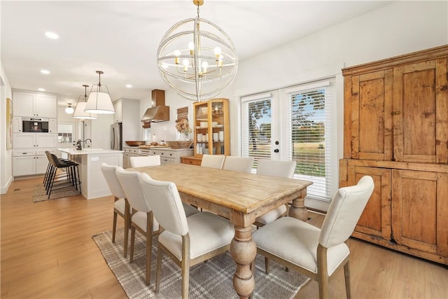 dining area featuring recessed lighting, a notable chandelier, light wood-style floors, and french doors