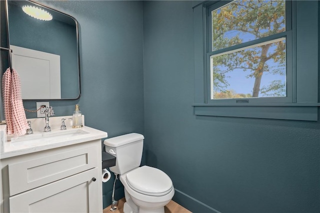 bathroom with vanity, toilet, and baseboards