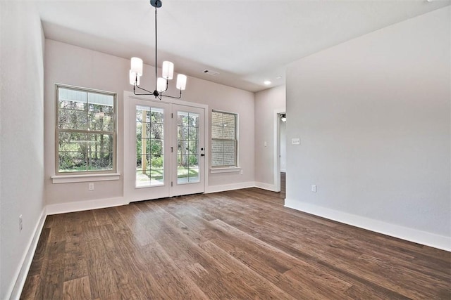 unfurnished dining area with baseboards, recessed lighting, wood finished floors, and a chandelier