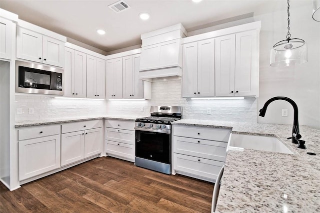 kitchen with white cabinetry, appliances with stainless steel finishes, a sink, and visible vents