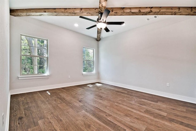 spare room with visible vents, beam ceiling, and wood finished floors
