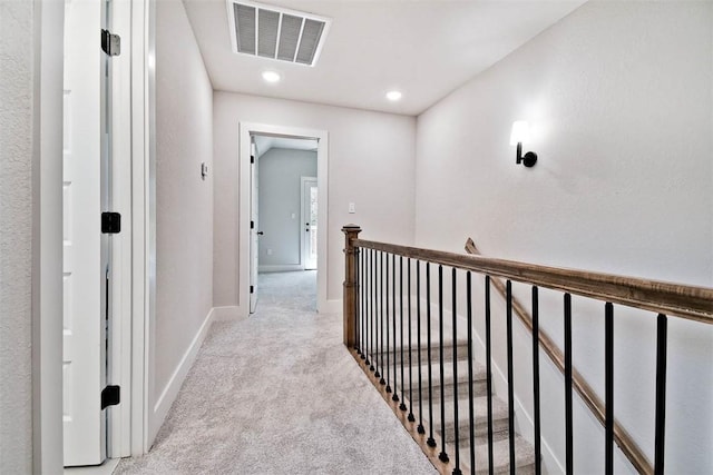 corridor with light carpet, recessed lighting, baseboards, an upstairs landing, and visible vents