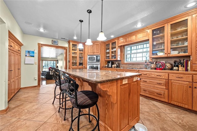 2428 Winn Mountain Loop, Mountainburg, AR 72946 - kitchen with light tile patterned flooring, a kitchen island, stainless steel appliances, and a healthy amount of sunlight
