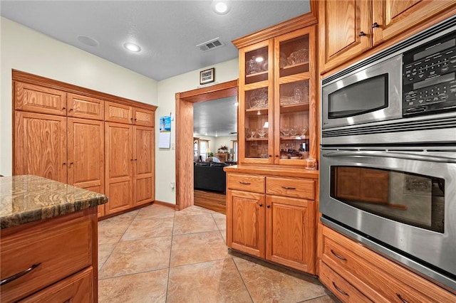 2428 Winn Mountain Loop, Mountainburg, AR 72946 - kitchen with double oven, glass insert cabinets, visible vents, and light tile patterned floors