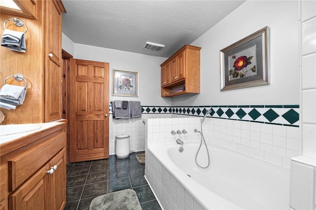2428 Winn Mountain Loop, Mountainburg, AR 72946 - full bath with tile walls, visible vents, tile patterned flooring, a garden tub, and vanity
