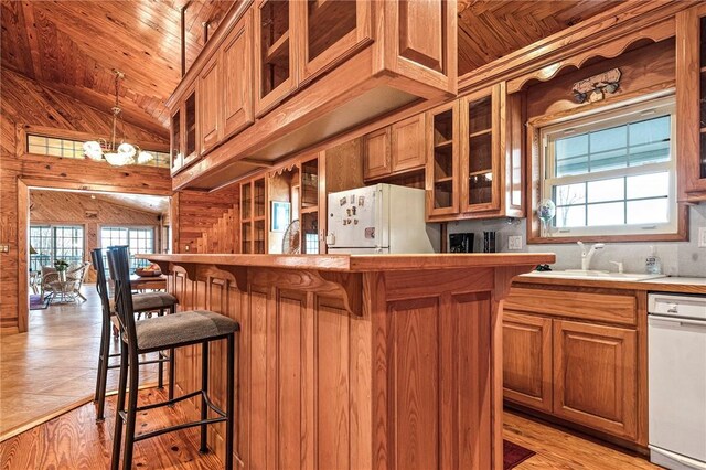 2428 Winn Mountain Loop, Mountainburg, AR 72946 - kitchen with brown cabinets, a kitchen breakfast bar, glass insert cabinets, and freestanding refrigerator