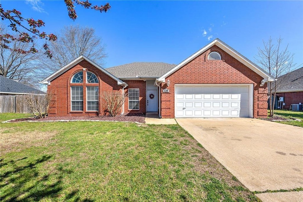 view of front of house featuring brick siding, a front lawn, concrete driveway, an attached garage, and central AC