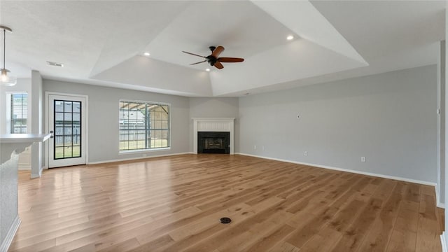 108 Birch St, Centerton, AR 72719 - unfurnished living room featuring a tray ceiling, a ceiling fan, light wood-type flooring, a fireplace, and baseboards