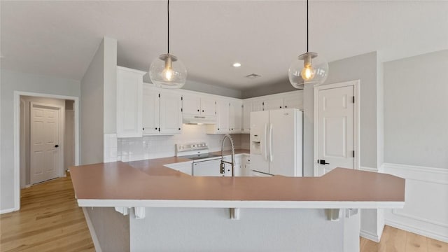 108 Birch St, Centerton, AR 72719 - kitchen featuring white appliances, light wood-style floors, tasteful backsplash, white cabinets, and under cabinet range hood
