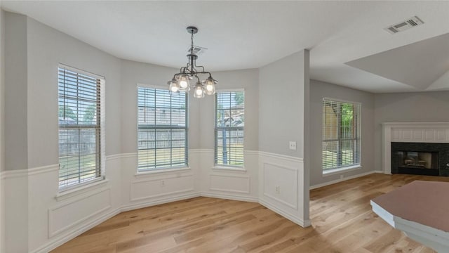 108 Birch St, Centerton, AR 72719 - unfurnished dining area featuring light wood finished floors, healthy amount of natural light, a wainscoted wall, and a chandelier