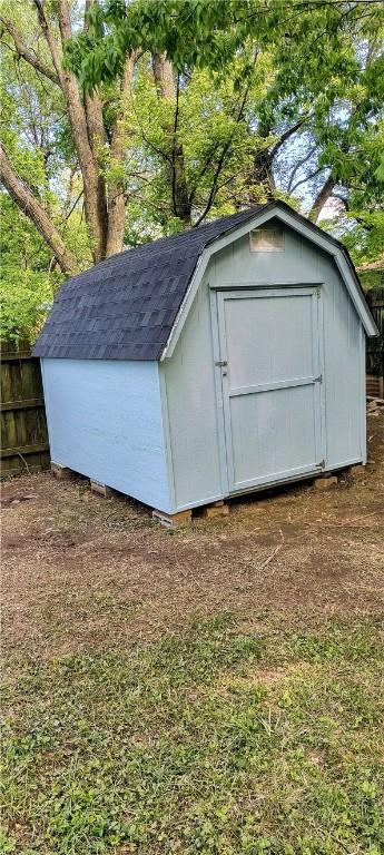 view of shed featuring fence