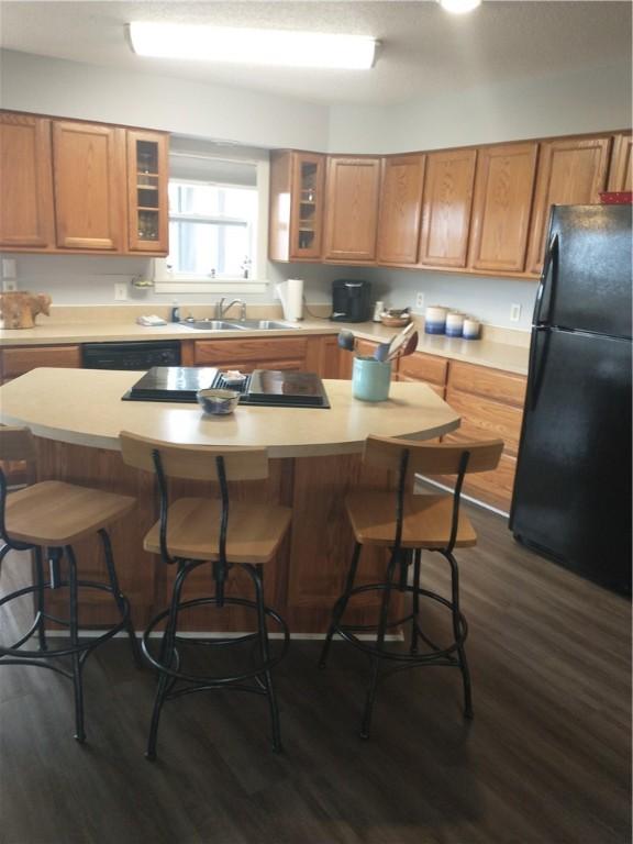 82 County Road 327, Berryville, AR 72616 - kitchen featuring freestanding refrigerator, dark wood-style floors, light countertops, a kitchen island, and glass insert cabinets