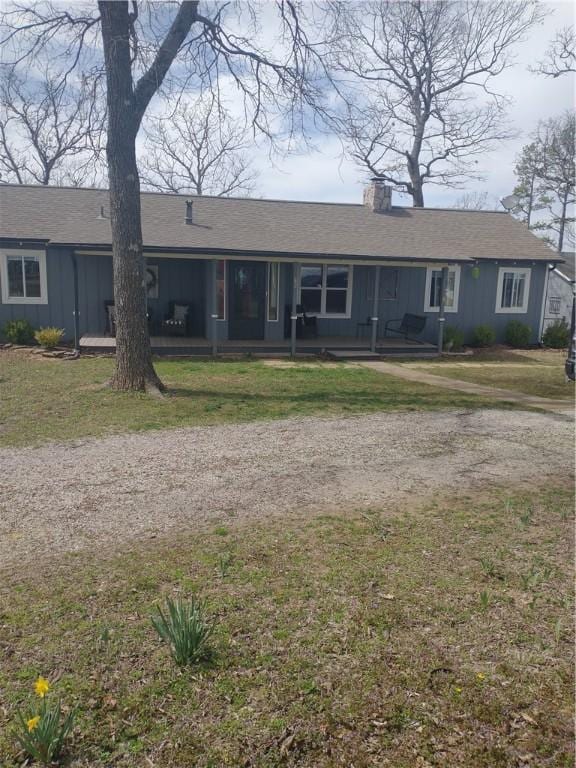 82 County Road 327, Berryville, AR 72616 - ranch-style house with a chimney, board and batten siding, and a front lawn