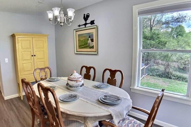 82 County Road 327, Berryville, AR 72616 - dining area with dark wood finished floors, a chandelier, healthy amount of natural light, and baseboards