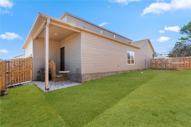 back of property featuring a gate, a patio, a fenced backyard, and a lawn
