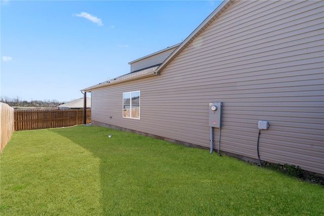 view of side of property with fence and a lawn