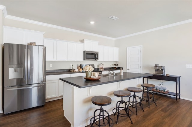 kitchen with stainless steel appliances, dark wood finished floors, dark countertops, visible vents, and ornamental molding