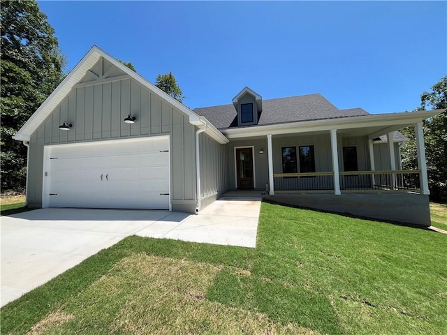 11 Romine Ln, Bella Vista, AR 72715 - view of front facade with board and batten siding, a garage, covered porch, a front lawn, and concrete driveway