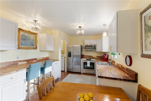 16101 Hickory Dr, Rogers, AR 72756 - kitchen featuring a sink, an inviting chandelier, butcher block countertops, and stainless steel appliances