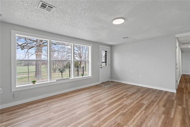 291 E Pilcher Rd, Kansas, OK 74347 - foyer with wood finished floors, healthy amount of natural light, a textured ceiling, and baseboards