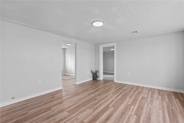 291 E Pilcher Rd, Kansas, OK 74347 - empty room featuring a textured ceiling, light wood-style floors, and baseboards