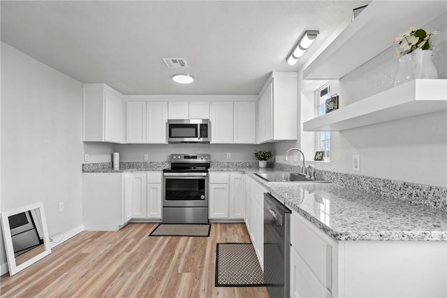 291 E Pilcher Rd, Kansas, OK 74347 - kitchen with stainless steel appliances, a sink, white cabinets, light wood-style flooring, and light stone counters
