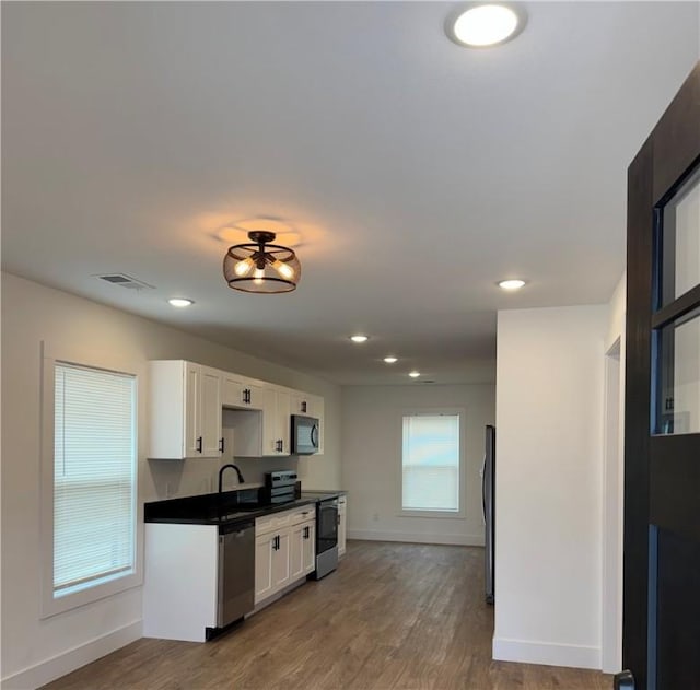 311 Douglas St, Berryville, AR 72616 - kitchen featuring white cabinets, wood finished floors, visible vents, and appliances with stainless steel finishes
