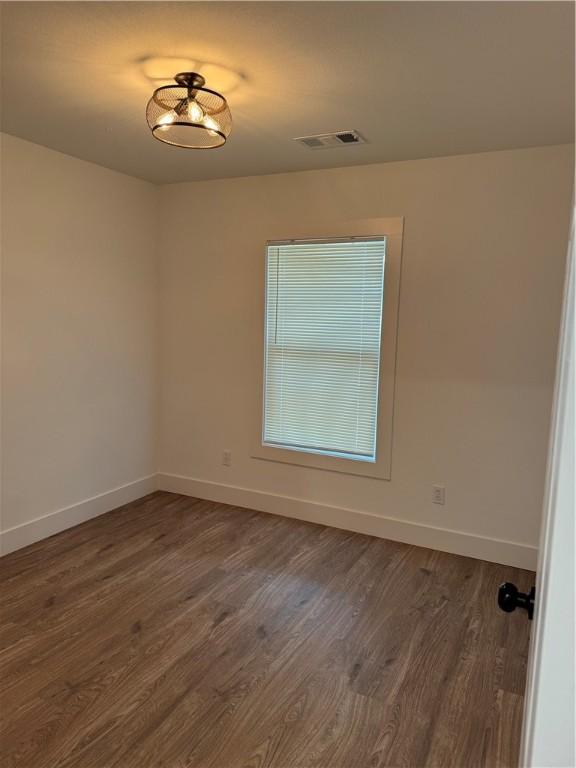 311 Douglas St, Berryville, AR 72616 - spare room featuring dark wood-style floors, visible vents, and baseboards