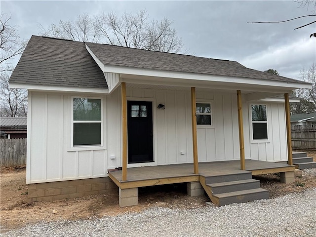 313 Douglas St, Berryville, AR 72616 - view of front facade with covered porch, fence, board and batten siding, and roof with shingles