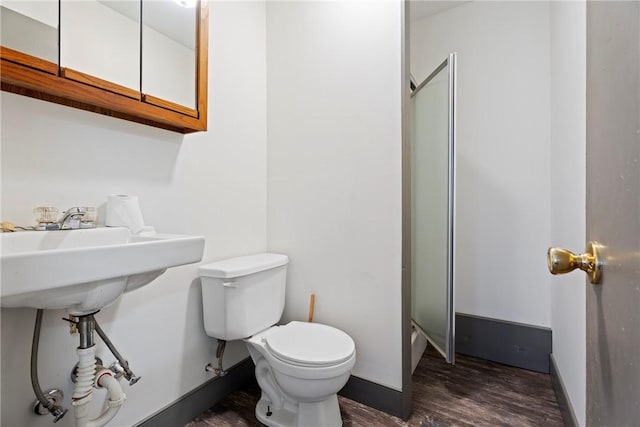 300 Range St, Marshall, AR 72650 - bathroom featuring toilet, baseboards, and wood finished floors