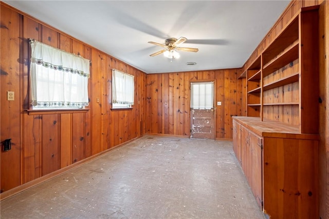 300 Range St, Marshall, AR 72650 - empty room featuring baseboards, wooden walls, a healthy amount of sunlight, and a ceiling fan